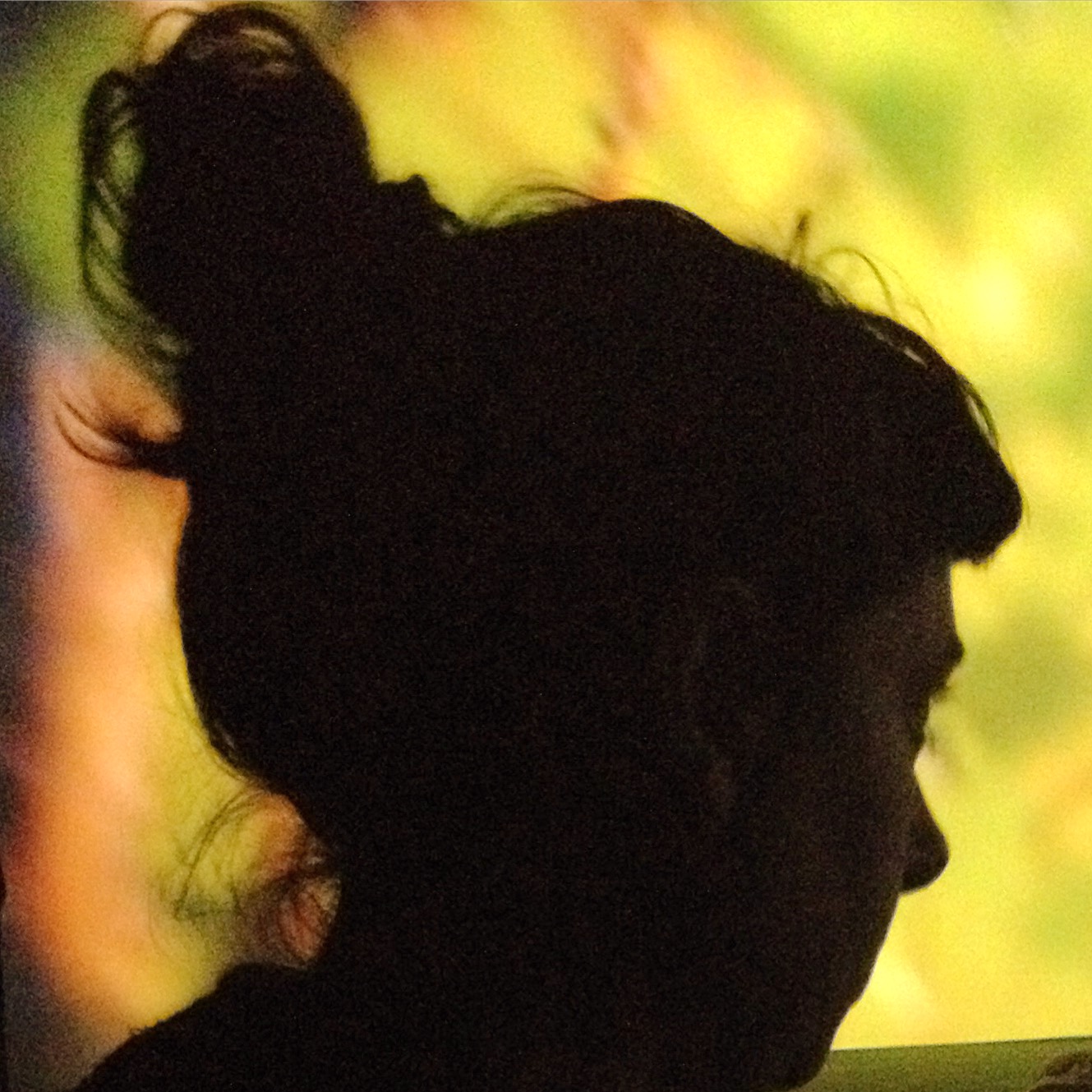 Photo of Professor Holly Rogers, a member of advisory board. Holly is silhouetted against a yellow background – she has dark hair in a high ponytail.