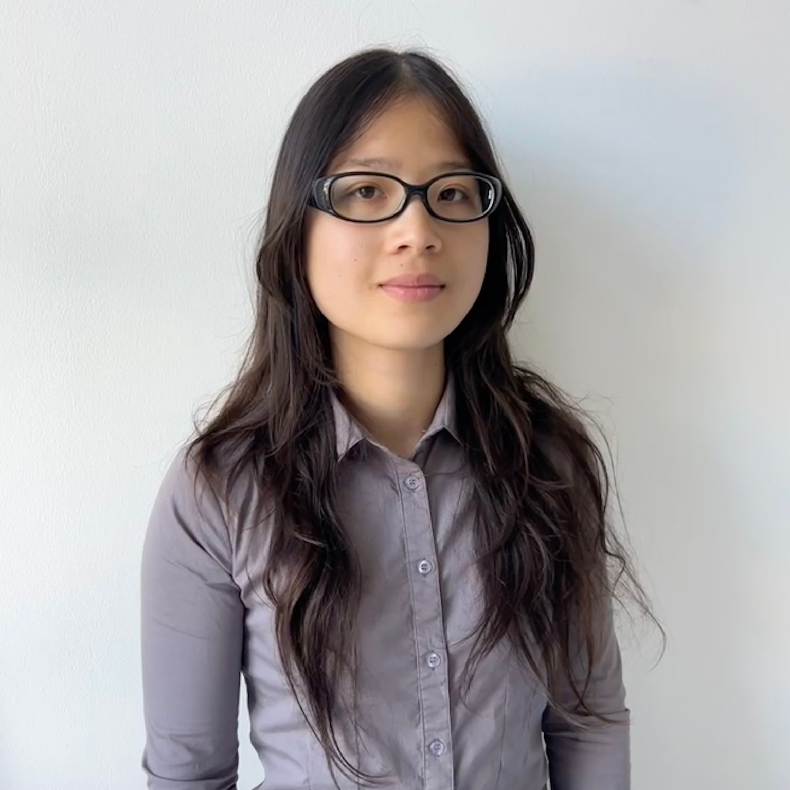 Headshot of Elissa Vinh, a member of the editorial board. Elissa has long dark hair and is wearing black-rimmed glasses and a grey shirt.